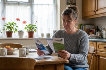 Femme moyenne âge étudie brochures santé dans sa cuisine